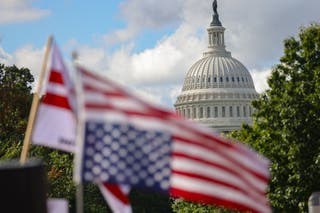 The dome of the U.S. Capitol building is seen beyond an upside-down U.S. flag during an anti-Trump protest at Union Station